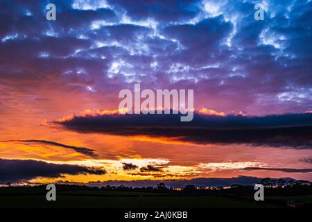 Coucher de soleil avec des nuages lumineux décembre et ciel bleu. Banque D'Images