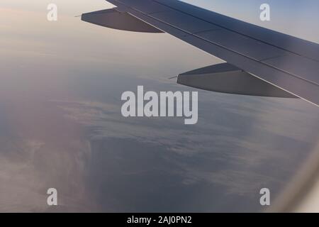 Aile d'avion sur les nuages, vole au-dessus de paysage de montagne Banque D'Images