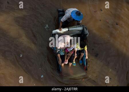 Jakarta, Indonésie. 2 Jan, 2020. Les gens monter un pedicab traditionnels grâce à l'eau des inondations à Jakarta, Indonésie, le 2 janvier 2020. À Jakarta, l'évacuation des personnes touchées par les inondations ont persisté comme les eaux encore submergée plusieurs parties de la ville, et six personnes ont été déclarées mortes dans la ville, a déclaré M. Ridwan, porte-parole de l'agence une catastrophe à Jakarta. Ti'Kuncahya Crédit : B./Xinhua/Alamy Live News Banque D'Images