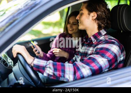 Couple romantique dans leur voiture partir en voyage. Jeune homme au volant de sa voiture avec un jour d'été. Banque D'Images