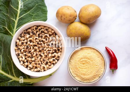 Vue aérienne de pois, de pommes de terre crues dolique, le poivron rouge et le chou vert sur une surface en marbre Banque D'Images