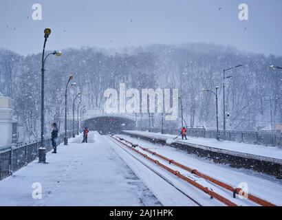 Kiev, UKRAINE - le 4 mars 2018 : la station de métro Dnipro plate-forme avec passagers train en attente et les travailleurs de la neige durant le nettoyage de neige, Kiev, Ukraine Banque D'Images