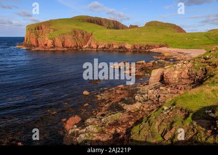 North Bay, jambon d'admission profonde, couverts de lichen d'immenses falaises de granit rouge, Muckle Roe Island, îles Shetland, Écosse, Royaume-Uni, Europe Banque D'Images