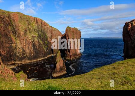 Jambon du nord, couvertes de lichen d'immenses falaises de granit rouge et de piles, Muckle Roe Island, îles Shetland, Écosse, Royaume-Uni, Europe Banque D'Images