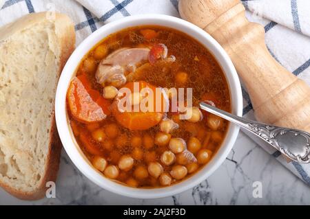 Soupe au poulet, petits pois, tomates et carottes en rondelles. Savoureuse soupe chaude. Banque D'Images