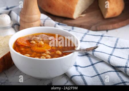Soupe au poulet, petits pois, tomates et carottes en rondelles. Savoureuse soupe chaude. Banque D'Images