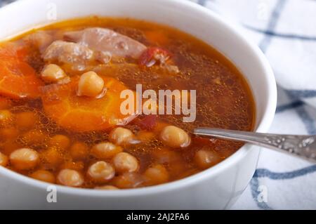 Soupe au poulet, petits pois, tomates et carottes en rondelles. Savoureuse soupe chaude. Banque D'Images