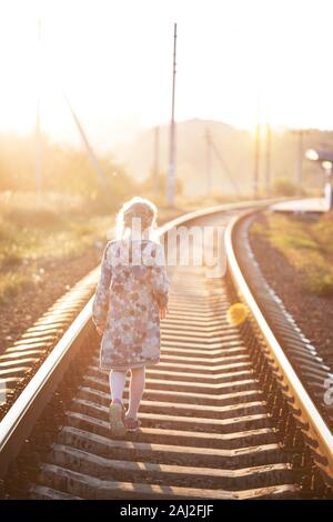 Fille marche sur l'heure du coucher du soleil à fer Banque D'Images