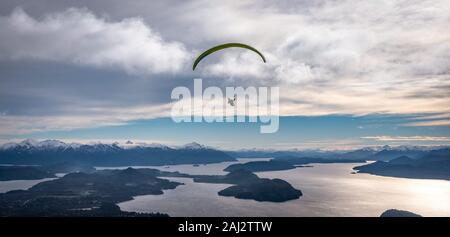 Vue panoramique de parapente sur le lac Nahuel Huapi et les montagnes de Bariloche en Argentine, avec des sommets enneigés en arrière-plan. Concept de liberté Banque D'Images