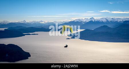 Vue panoramique de parapente sur le lac Nahuel Huapi et les montagnes de Bariloche en Argentine, avec des sommets enneigés en arrière-plan. Concept de liberté Banque D'Images