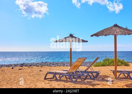 Plage avec parasols et chaises longues au bord de la mer dans une station balnéaire de sunny summer day Banque D'Images