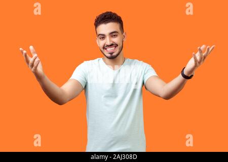 Venez me donner hug. Portrait de l'homme généreux positive brunette avec de barbe blanche occasionnels t-shirt tenant les mains posées et large ouvert à embrasser. je Banque D'Images