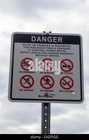 Burlington (Ontario), Canada, 2 janvier 2020: Panneau blanc avec lettres noires et symboles rouges indiquant que l'accès est interdit en raison de la présence de plusieurs danges Banque D'Images