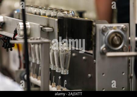 Nouvelle bière bouteilles vides en verre blanc ligne inversé sur l'eau de lavage sous pression machine pneumatique, électrique de l'usine d'embouteillage de microbrasserie craft brewery Banque D'Images