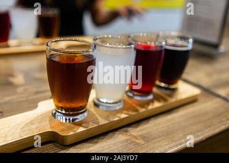 Vol de Plaisance de quatre bières différentes lunettes, brun noir blanc et rouge bière sur un plateau en bois au cours d'une dégustation, selective focus, copy space Banque D'Images