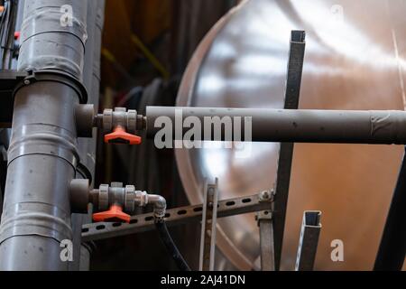 Deux petits tubes, tuyaux avec valves connectées à un grand grand isolement et couverts, dans une atmosphère poussiéreuse, selective focus, les réservoirs et les flexibles background Banque D'Images