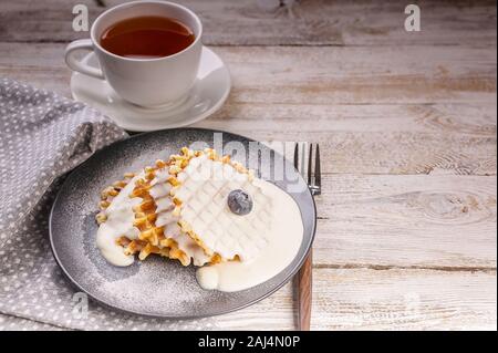 Gaufres aux bleuets et crème glacée et une tasse de thé. Le Dessert. La cuisson à la maison. Copy space Banque D'Images