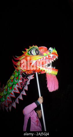 Un dragon marionnette est joué par un homme avec un bâton dans la célébration du Nouvel an chinois festival. Banque D'Images