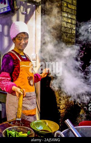 Xi'an, Chine - Avril 2015 : un fournisseur au service de la célèbre spécialité de Xian, plat de nouilles biang biang mian, dans le marché nocturne de la rue musulmane dans la ville de Banque D'Images