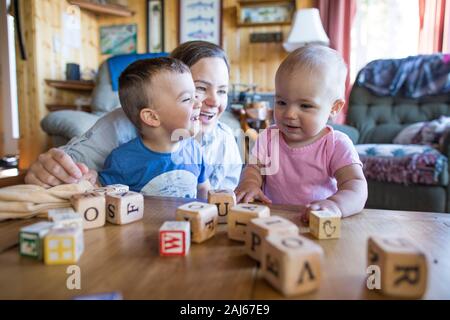 Mère jouant à l'intérieur avec ses deux enfants. Banque D'Images