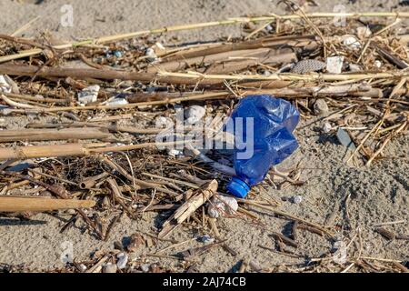 Bouteille en plastique bleu sur la côte de la mer polluée écosystème après la tempête, le Cilento Banque D'Images