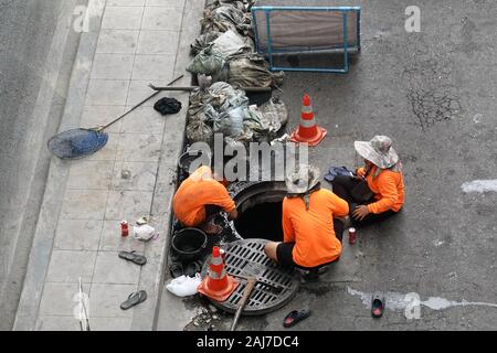 Bangkok, Thaïlande - le 21 décembre 2019 : Les travailleurs d'égout nettoyage avec les seaux et les sacs à déchets à net scoop. Banque D'Images