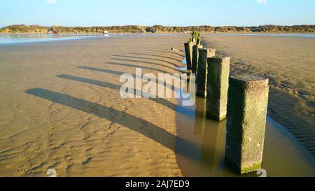 Posts sur la plage à marée basse à Berrow, Somerset, Angleterre, Royaume-Uni Banque D'Images