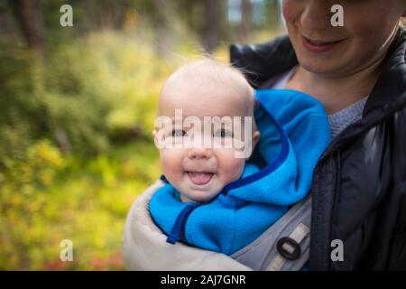 Portrait de la mère tenant le bébé dans un porte-bébé avant. Banque D'Images