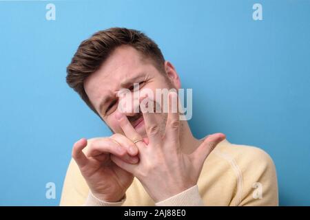 L'homme essaie de mettre hors bande de mariage de son doigt. Penser à la méditation ou le mariage. Banque D'Images