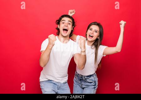 Photo de charme gai beau beau couple de deux personnes se réjouir avec la victoire de quelque chose tout en portant des t-shirts avec red isolés Banque D'Images