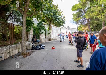 ALBEROBELLO, ITALIE - 28 août 2018 - Belle vieille ville d'Alberobello Trulli blanchis à carreaux en pierre maisons toit conique en Pouilles est visité chaque année par des millions de touristes. Musicien de rue Banque D'Images