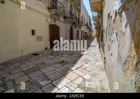 Bari, Italie - 28 août 2018 - Locorotondo dans les Pouilles, région des Pouilles, Italie du Sud est une petite ville à l'architecture étonnante, des rues étroites et atmosphère chaude. Rue étroite, décrués patio Banque D'Images