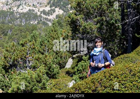 Vue avant du smiling hispanic woman standing tout en tenant un appareil photo Banque D'Images