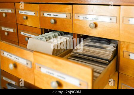 Un fichier cabinet ou cabinet avec un tiroir et des fichiers. Concept de base de données. Armoire à dossiers avec la bibliothèque ou le bureau. Deux tiroirs ouverts. Bureau ancien Banque D'Images