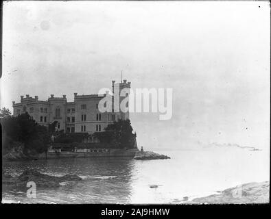 Château de Miramare est un château du xixe siècle dans le Golfe de Trieste, près de Trieste, au nord-est de l'Italie. Il a été construit de 1856 à 1860 pour l'archiduc autrichien Ferdinand Maximilien et son épouse, Charlotte de Belgique, plus tard l'Empereur Maximilien I et de l'Impératrice Carlota du Mexique, fondé sur une conception par Carl Junker. Photographie datée autour de 1910-1920. Un bateau croisière avec un énorme nuage de fumée sur le côté droit. Copier à partir d'une plaque de verre à sec, provenant de l'Herry W. Schaefer collection. Banque D'Images