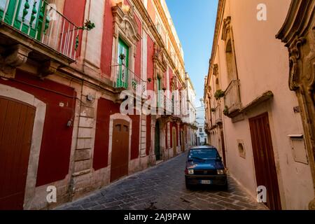 Bari, Italie - 28 août 2018 - Locorotondo en Pouilles, Italie du Sud est une petite ville à l'architecture, ses rues étroites et atmosphère chaude. Quartier résidentiel avec petite vieille voiture Fiat Banque D'Images