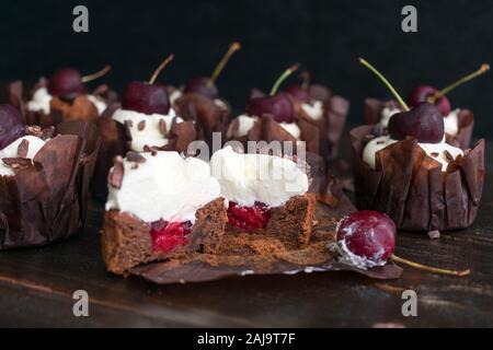 Cupcake Forêt noire avec garniture aux cerises : cupcake au chocolat avec garniture aux cerises et à la crème fouettée en tête coupée en deux Banque D'Images