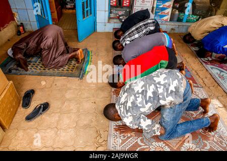 Les musulmans prier à l'extérieur de l'extérieur d'un atelier à Ouagadougou, Burkina Faso Banque D'Images