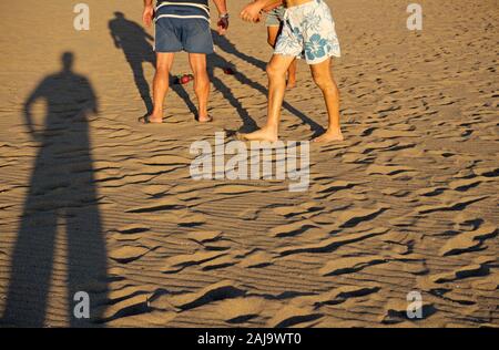 Les hommes jouant le jeu de boules lyonnaises sur plage de sable en Italie Banque D'Images