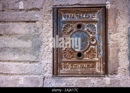 Ancienne plaque insérée dans un appareil de mesure de l'enceinte médiévale à côté du palais ducal à Gubbio, ville médiévale en Ombrie dans la province de Pérouse, 100 Banque D'Images
