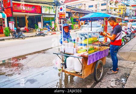 PATONG, THAÏLANDE - 30 avril 2019 : le vendeur de rue au panier alimentaire avec grillades de poissons et de poulet sur les brochettes, le 30 avril à Patong Banque D'Images