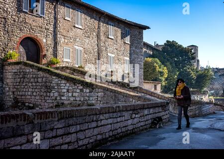 GUBBIO, ITALIE - janvier 01, 2020 : pas de femme avec chien à les ponts de l'abondance dans le village de Gubbio, une ville médiévale en Ombrie dans la provin Banque D'Images