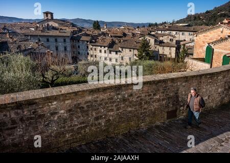 GUBBIO, ITALIE - janvier 01, 2020 : homme inconnu promenades le long de la rue de la Cathédrale avec la vue panoramique de la ville de Gubbio, une ville médiévale à l'Umb Banque D'Images