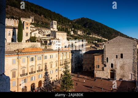GUBBIO, ITALIE - janvier 01, 2020 : des inconnus dans la Piazza Grande avec le Palais Prétorien à Gubbio, une ville médiévale en Ombrie dans la province Banque D'Images