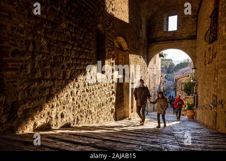 GUBBIO, ITALIE - janvier 01, 2020 : des inconnus à pied sous l'arche Piccardi road à Gubbio, une ville médiévale en Ombrie dans la province de Pérouse Banque D'Images