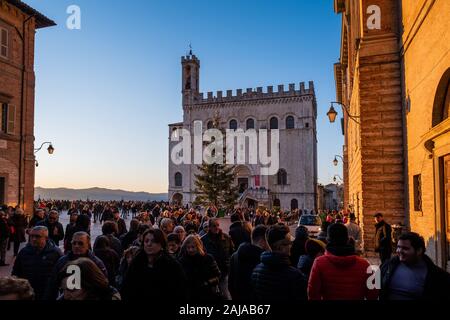 GUBBIO, ITALIE - janvier 01, 2020 : des inconnus dans la Piazza Grande avec le Palazzo dei Consoli à Gubbio, une ville médiévale en Ombrie dans la provinc Banque D'Images