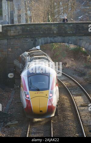 Un homme regardant un nouveau train Azuma qui se déplace sous un pont à Harrogate, dans le North Yorkshire, en Angleterre, au Royaume-Uni. Banque D'Images