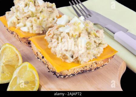 Une salade de thon et saumon face sandwich avec une tranche de cheddar sur le dessus de la poitrine de fusion de grain entier de blé semé des petits pains. Banque D'Images