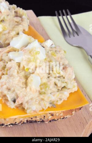 Une salade de thon et saumon face sandwich avec une tranche de cheddar sur le dessus de la poitrine de fusion de grain entier de blé semé des petits pains. Banque D'Images