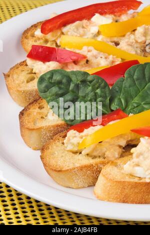 Face ouverte baguette grillées avec des sandwiches thon germon et de saumon rose sauvage. Les poivrons et les feuilles d'épinards sont saisies. Banque D'Images